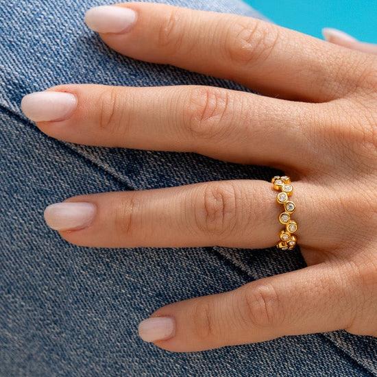 Anello dorato resistente all'acqua con piccoli zirconi brillanti.