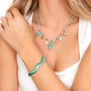 Dettaglio del bracciale Oceania dorato con motivo ondulato smaltato nei toni del turchese e del verde acqua.