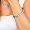 Dettaglio del bracciale Positano dorato con smalto azzurro e giallo e chiusura a scatto.