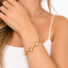 Bracciale Sole in acciaio inossidabile waterproof color oro con ciondoli a forma di sole e dettagli smaltati multicolore, indossato al polso.