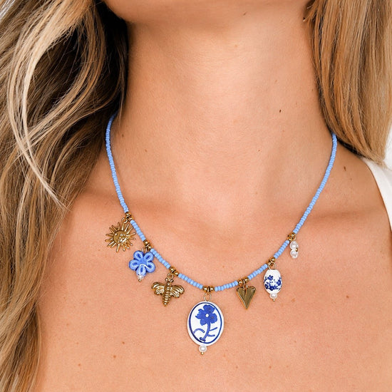 Collana Maiolica con ciondoli bianchi e blu e perline azzurre, indossata