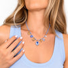 Pendente ovale della Collana Maiolica con fiore blu su fondo bianco e bordo dorato.