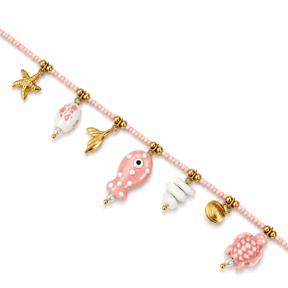 Collana Pesciolino Acheta Jewels, con perline rosa e pendenti marini, tra cui un pesce a pois bianchi.
