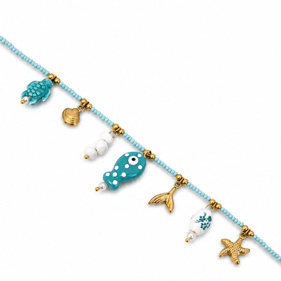 Collana con perline turchesi e ciondoli marini  dettaglio del pesciolino centrale.