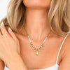 Collana Sacro Cuore in acciaio inossidabile waterproof color oro con perline bianche e ciondolo cuore sacro, indossata.